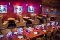 a restaurant with wooden tables and chairs and red walls at iHOTEL & Conference Centre Red Deer in Red Deer