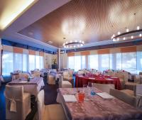 Un comedor con mesas y sillas y ventanas. en Monica Hotel Fiera, en Pregnana Milanese