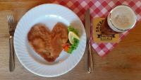 a white plate with a heart shaped fish and a drink at Klindworths Gasthof in Sauensiek