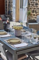 einen Tisch mit Tellern und Weingläsern darauf in der Unterkunft Home Emoi in La Gouesnière