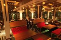 a view of a restaurant with red benches and tables at Resort Titli in Shānti Niketan
