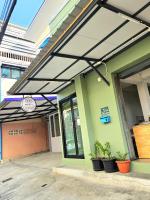 Markierung auf der Seite eines Gebäudes mit Topfpflanzen in der Unterkunft KK Poshtel in Don Muang Airport