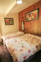a bedroom with two beds and two pictures on the wall at Pousada Sino dos Ventos in Campos do Jordão