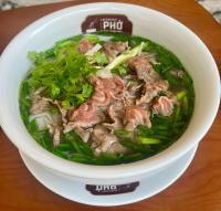 Un tazón de sopa con carne y verduras en una mesa. en Legend Smart Hotel, en Phú Thú