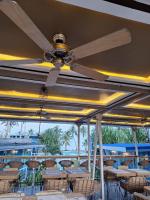 un ristorante con tavoli e sedie e un ventilatore a soffitto di Apsaras Tribe Siargao a Catangnan