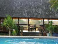 a resort with a swimming pool in front of a building at Rio Vista Lodge in Malelane