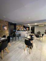 Un restaurante con mesas y sillas y un bar. en Hostal La Masia, en Manresa