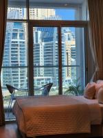 Schlafzimmer mit einem großen Fenster mit Stadtblick in der Unterkunft STUDIO ONE Stunning Marina View - TIE Hotels &amp; Resorts in Dubai