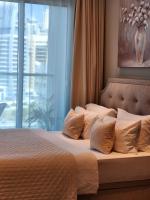 ein Bett mit Kissen in einem Schlafzimmer mit Fenster in der Unterkunft STUDIO ONE Stunning Marina View - TIE Hotels &amp; Resorts in Dubai