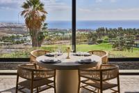 Royal Hideaway Corales Villas في أديخي: غرفة طعام مع طاولة وكراسي ونافذة كبيرة