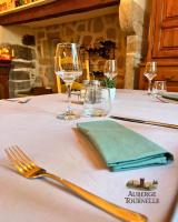 una mesa con un tenedor y copas de vino. en Auberge La Tournelle, en Saint-Jean-de-Valériscle