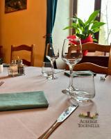 Una mesa con dos copas de vino y una servilleta verde. en Auberge La Tournelle, en Saint-Jean-de-Valériscle