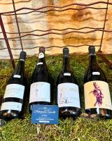 cuatro botellas de vino sentadas en la hierba en Auberge La Tournelle, en Saint-Jean-de-Valériscle