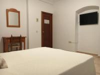 a bedroom with a bed and a mirror and a television at Hostal Barbate in Barbate