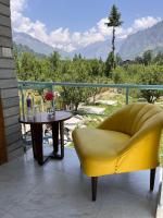 a yellow chair and table on a balcony with a view at Hotel Old Manali-Mountain View, Balcony, Garden, Pet Friendly, Parking in Manāli
