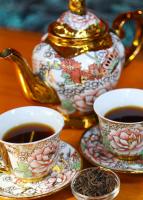 a table with two cups of tea and a teapot at Seahouse Bali Indah Beach Inn in Kuta