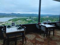 Un restaurante con mesas y sillas y un gran ventanal. en Sun Valley Hotel, en Yeoju