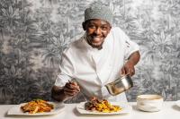 哈拉雷The Manor House的一位厨师手里拿着一个锅和一盘食物。