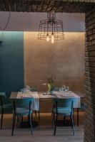 un comedor con 2 mesas y una lámpara de araña en Elide Design Hotel, en Asís