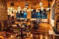 a restaurant with tables and chairs and chandeliers at Pickwick Park View Hotel in Belize City