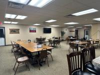 una sala conferenze con tavoli, sedie e TV di Selby Motel a Selby