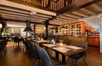 een restaurant met houten tafels en stoelen en een bar bij Chalet am Rhederlaag in Lathum