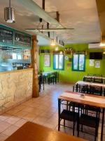 Turul Panzió&Pizzéria في Szólád: مطعم به طاولات وكراسي وجدران خضراء