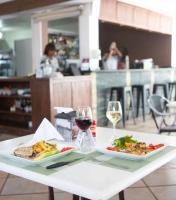 uma mesa com dois pratos de comida e um copo de vinho em New Garden Hotel em Sosúa