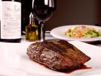 um pedaço de bife num prato com um copo de vinho em Loft de Lujo en Torre Punta Mayor frente a Plaza Mayor en León Gto em Miravalle