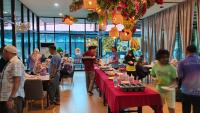 a group of people standing around tables in a restaurant at Trang Oasis Waterpark Hotel in Trang