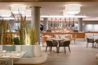 a restaurant with tables and chairs and a bar at Plus Fariones Suite Hotel in Puerto del Carmen