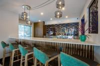a bar with blue chairs and a counter at voco Flagstaff by IHG in Flagstaff