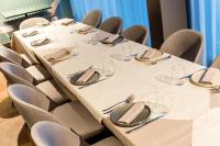 泰尔莫利Lumia Hotel的一间会议室,配有桌椅、眼镜和餐巾