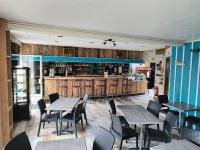 a restaurant with tables and chairs and a bar at La Marie Galante Appart'Hotel in Saint-Georges-dʼOléron