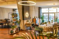 塔尔努夫塔诺威酒店的有桌椅和植物的餐厅