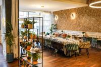 塔尔努夫塔诺威酒店的有桌椅和植物的餐厅