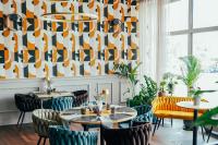 塔尔努夫塔诺威酒店的餐厅设有桌椅和图案墙壁