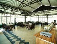 フンザにあるHunza Elites hotelのテーブルと椅子と窓のあるダイニングルーム