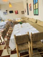 a dining room with a long table and chairs at Qodwa Palace Riad & SPA in Fourou