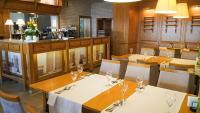a restaurant with tables and chairs and a bar at Hotel Antek in Zlinice