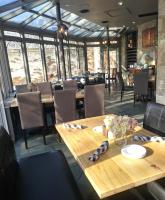 una sala da pranzo con tavoli, sedie e finestre di The Breadalbane Inn a Fergus