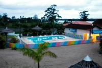 a large swimming pool with a colorful fence next to a building at Hotel Marina Clube de Pesca in Cananéia