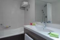 ein weißes Badezimmer mit Waschbecken und Spiegel in der Unterkunft Leonardo Privilege Eilat Hotel - All inclusive in Eilat