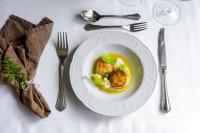 a white plate with a dish of food on a table at Røisheim Hotel & Skysstasjon in Lom