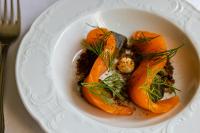 a white bowl of food with carrots on a plate at Røisheim Hotel & Skysstasjon in Lom