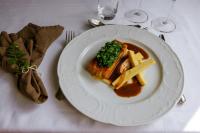a plate of food with fries on a table at Røisheim Hotel & Skysstasjon in Lom