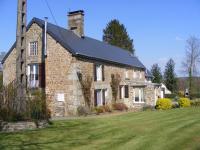 a large brick house with a grass yard in front of it at La Bannerie in Mesnil-Clinchamps