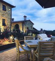 eine Terrasse mit Tisch und Stühlen und ein Gebäude in der Unterkunft Villa il Castagno Wine & Resort in Siena