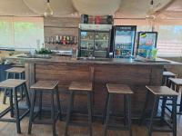 eine Bar mit Holzhockern und einer Theke in der Unterkunft Gold Guest & Conference in Welkom