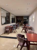 une salle d'attente avec des tables et des chaises et une télévision dans l'établissement Dyafa Pyramids Hotel & Spa, au Caire